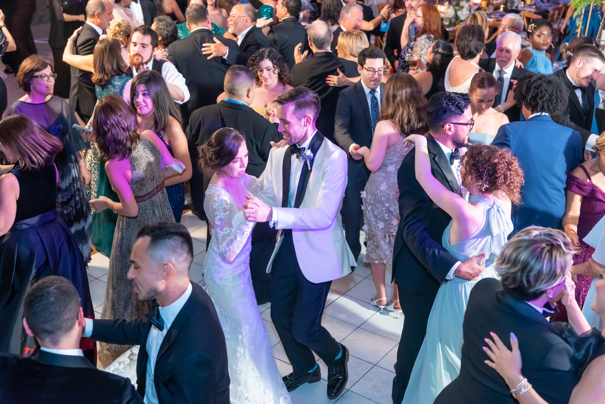 Newlyweds dancing, surrounded by friends and family