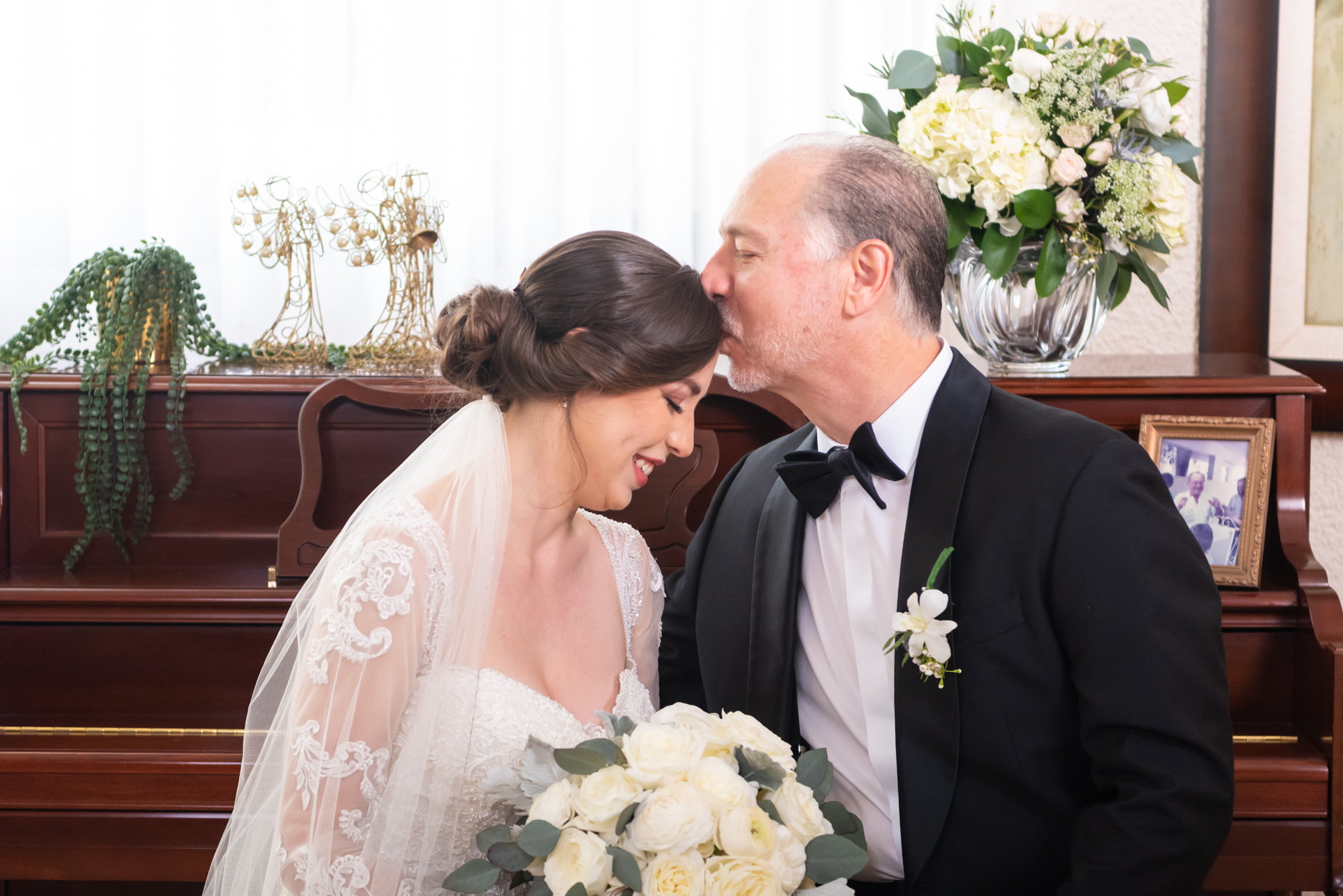 Bride's dad kissing her in the forehead