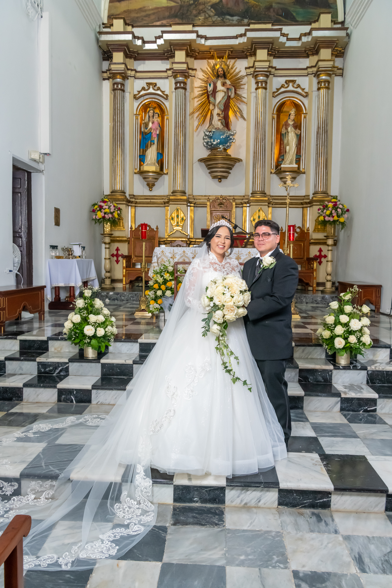 Pareja de recien casados posan frente al altar en la Parroquia San Blás de Coamo