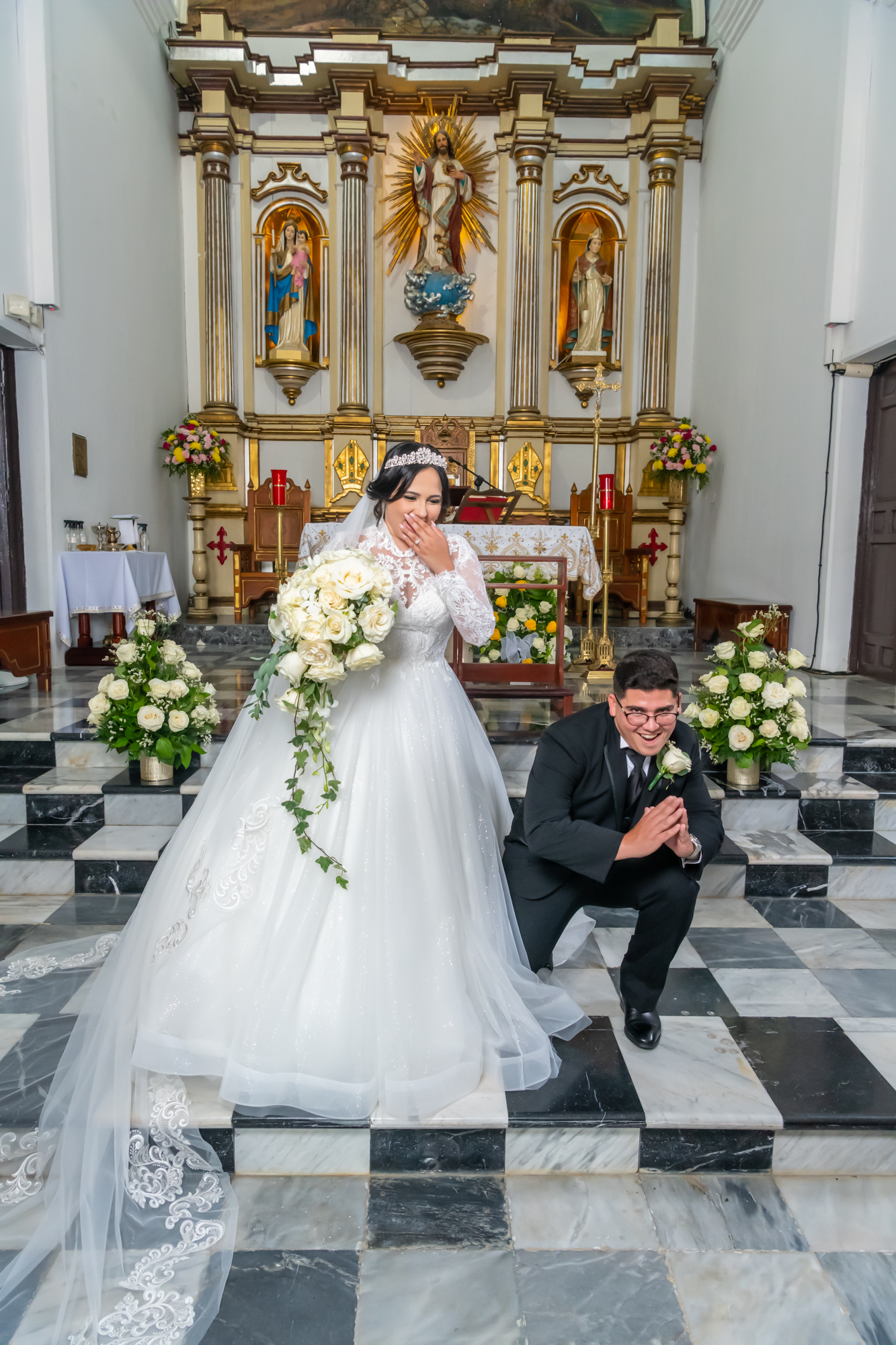 Pareja de recien casados posan de manerja graciosa frente al altar en la Parroquia San Blás de Coamo