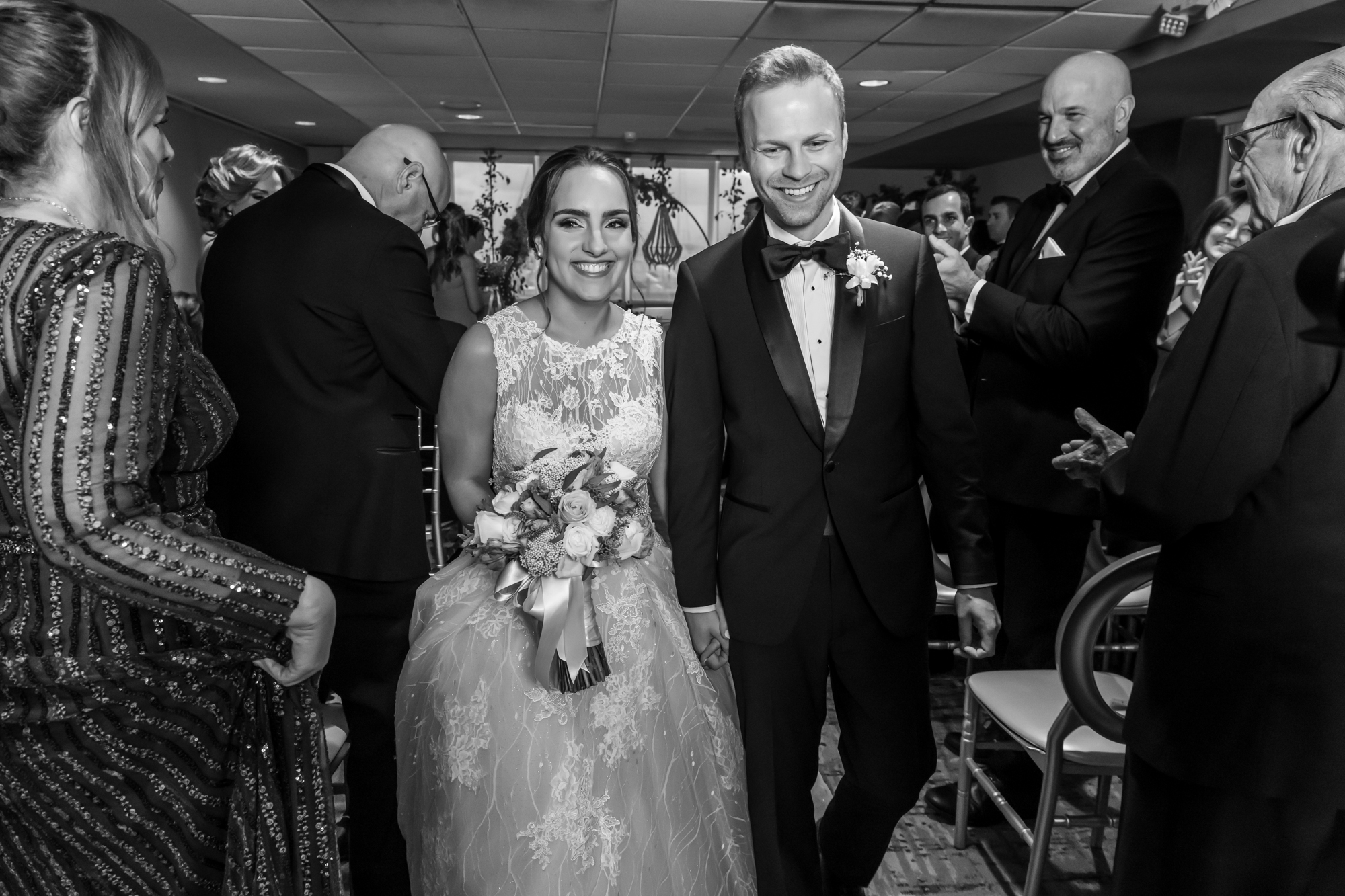 Black and white rendition of couple walking out the ceremony