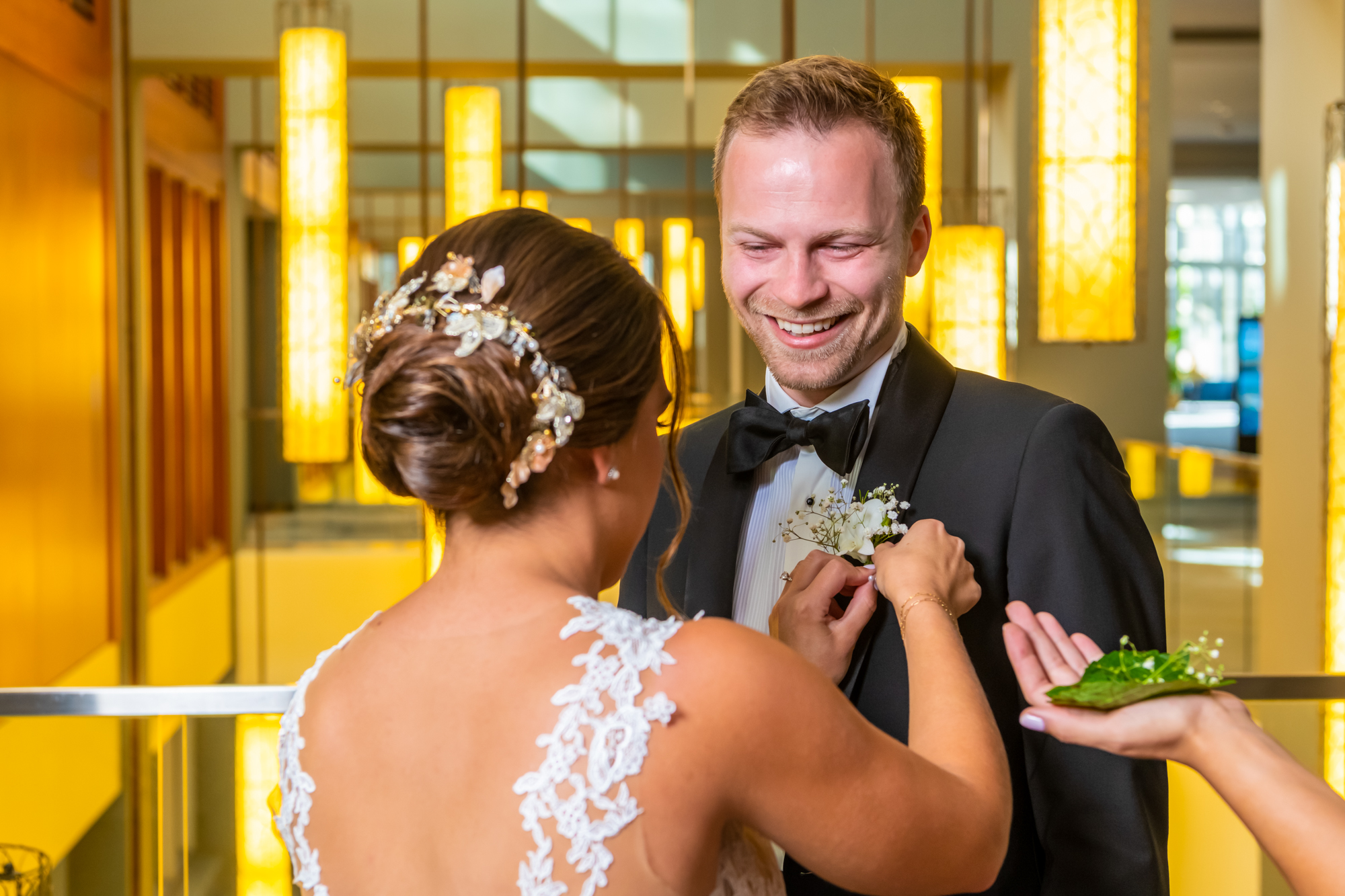 Bride helping to put groom's boutonniere