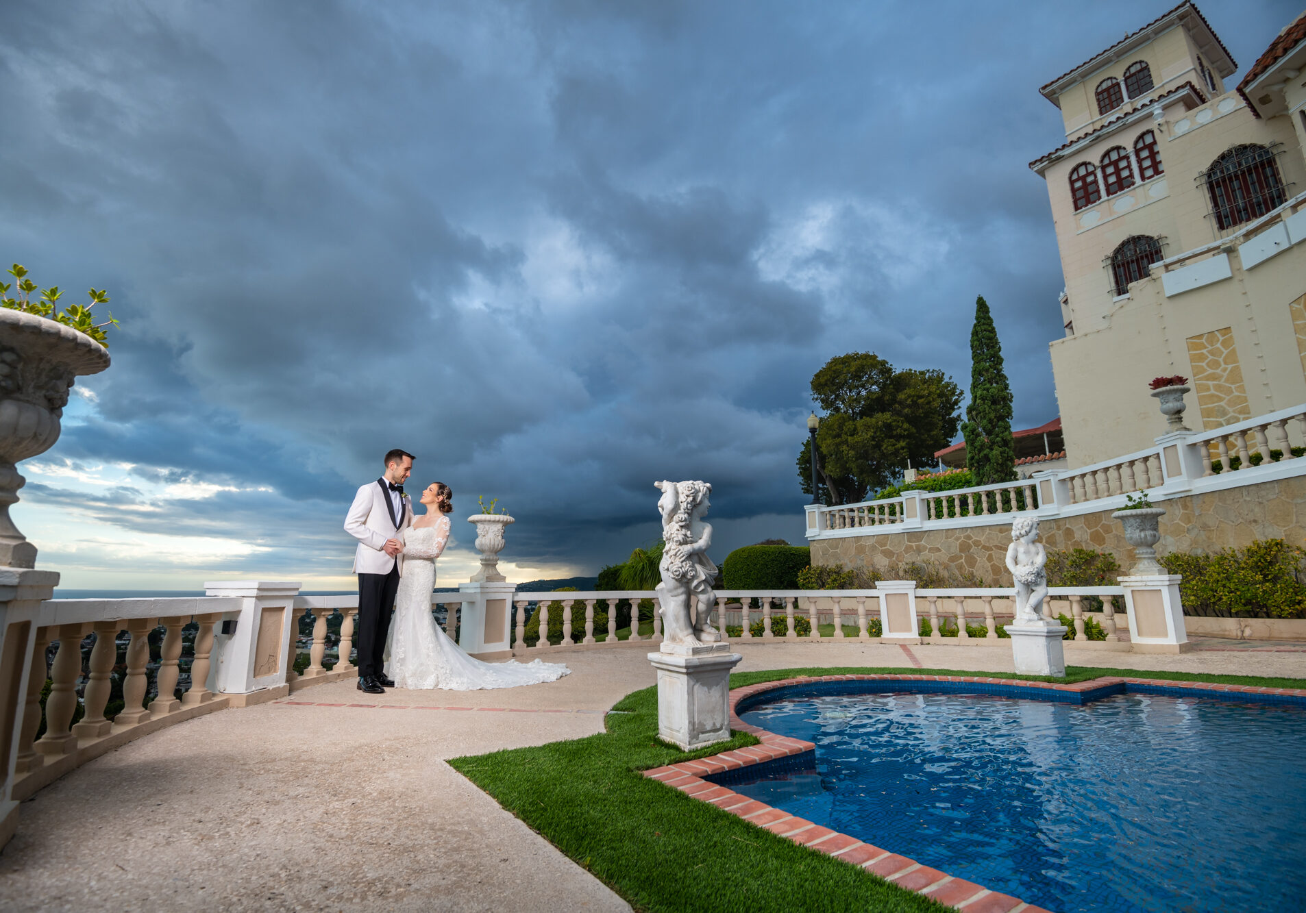 Newlyweds holding each other in majestic view of Castillo Serrallés
