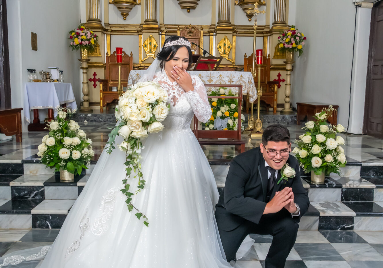 Pareja de recien casados posan de manerja graciosa frente al altar en la Parroquia San Blás de Coamo
