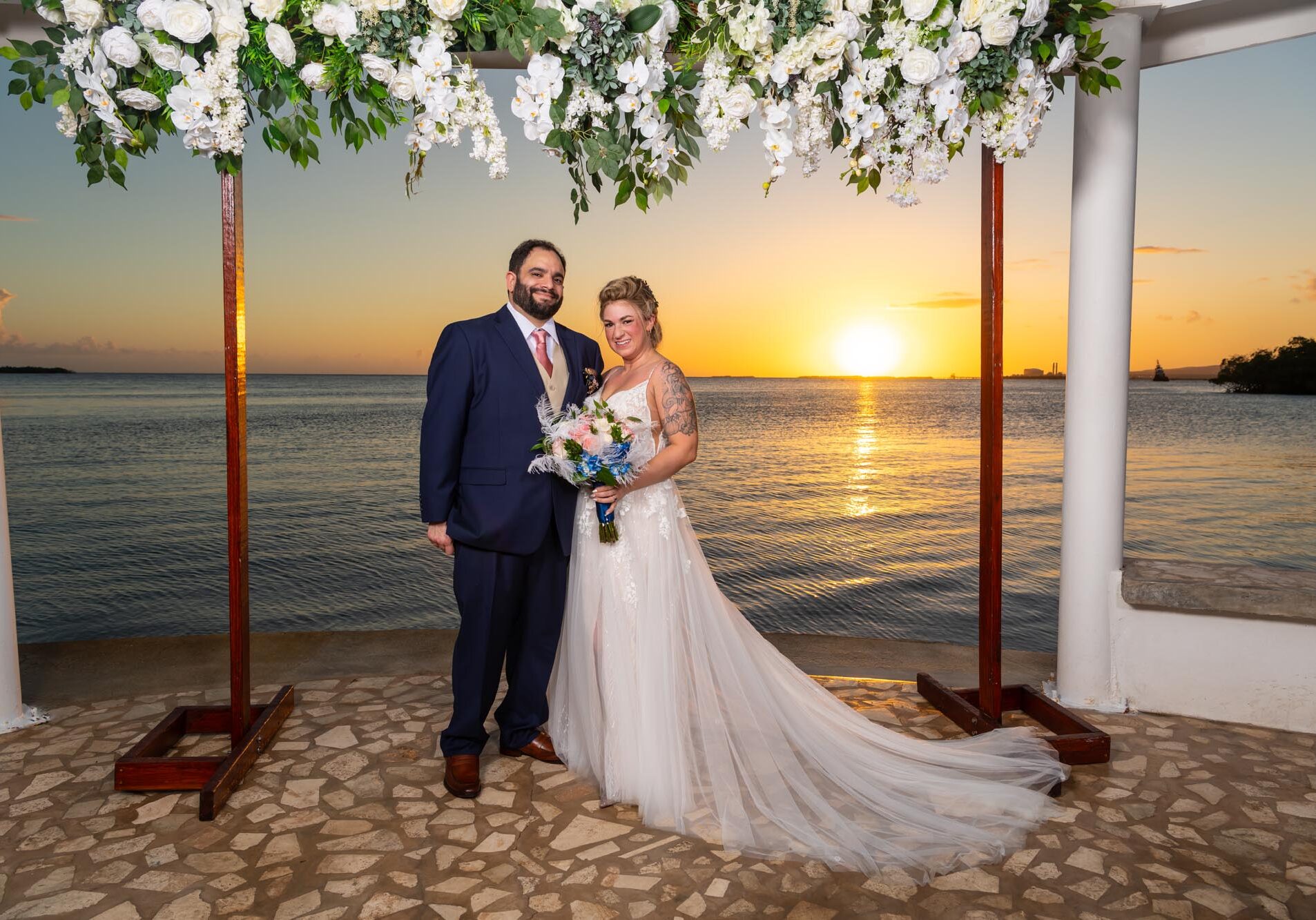 Bride and Groom posing and a beautiful sunset behind them
